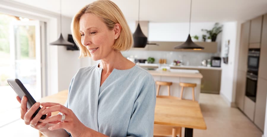 Woman using a mobile device in a room filled with sunlight